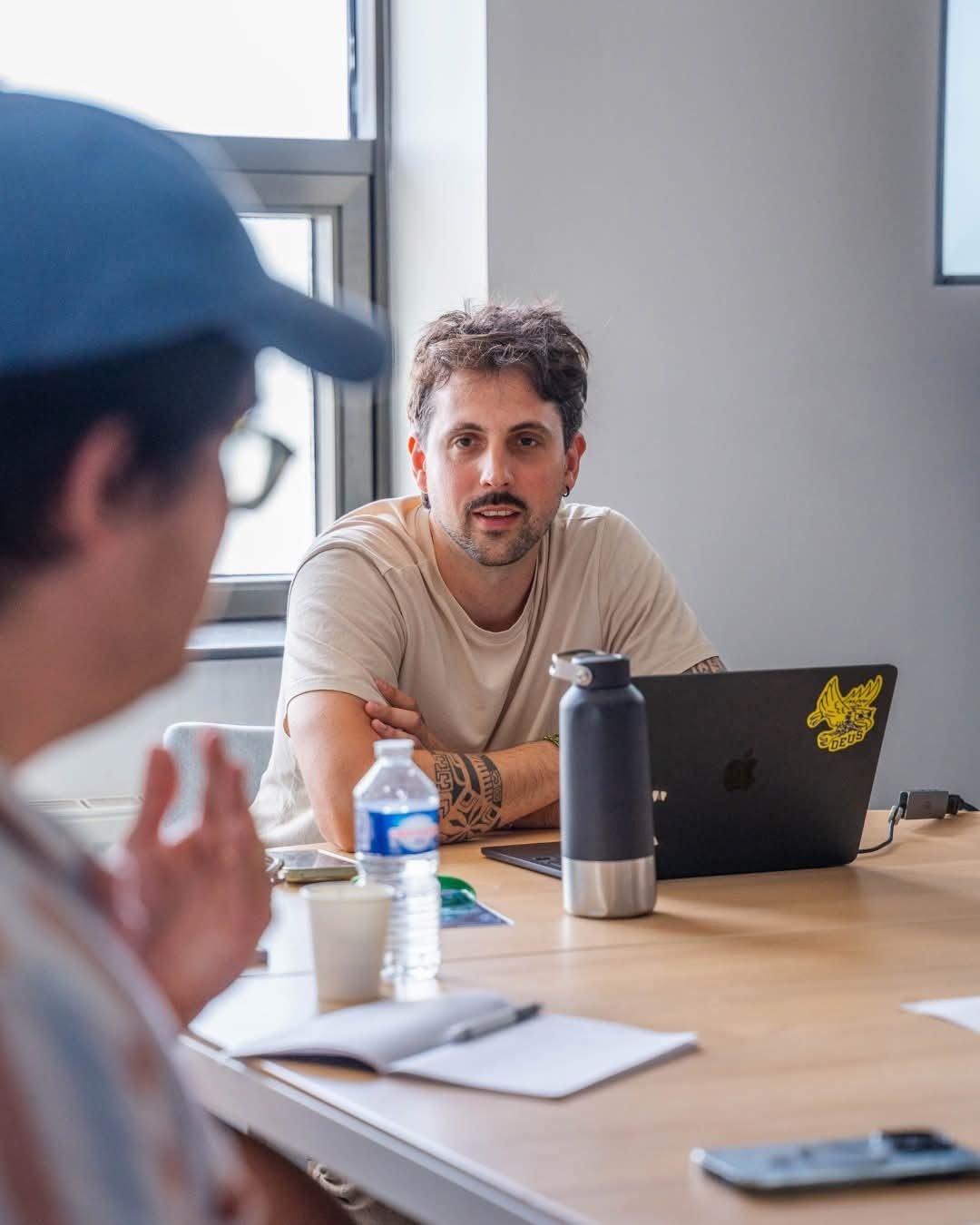 Gwennaël en rendez-vous de travail avec un client, ordinateur ouvert sur la table